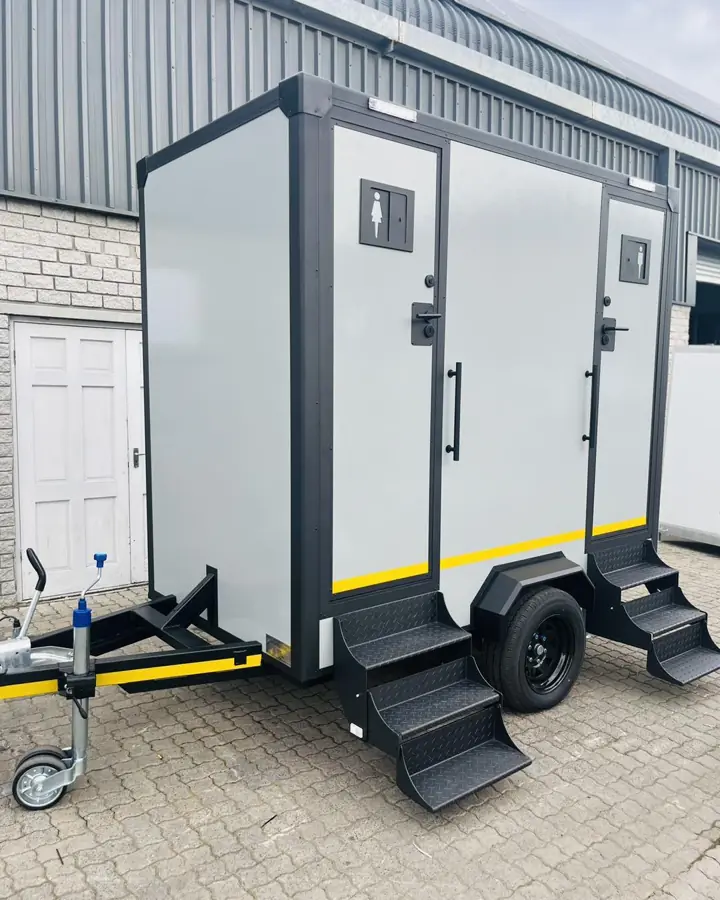 Two-station restroom trailer with men's and women's doors and fold-down steps