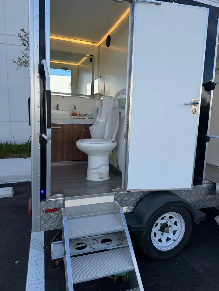 VIP trailer stall with porcelain toilet, wood vanity and LED lighting